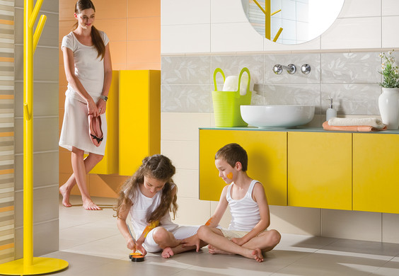 RAKO | Koupelna s lesklým melírovaným tiskem v kombinaci bílé, oranžové a šedé. Jako doplněk dekorované obklady a listely.